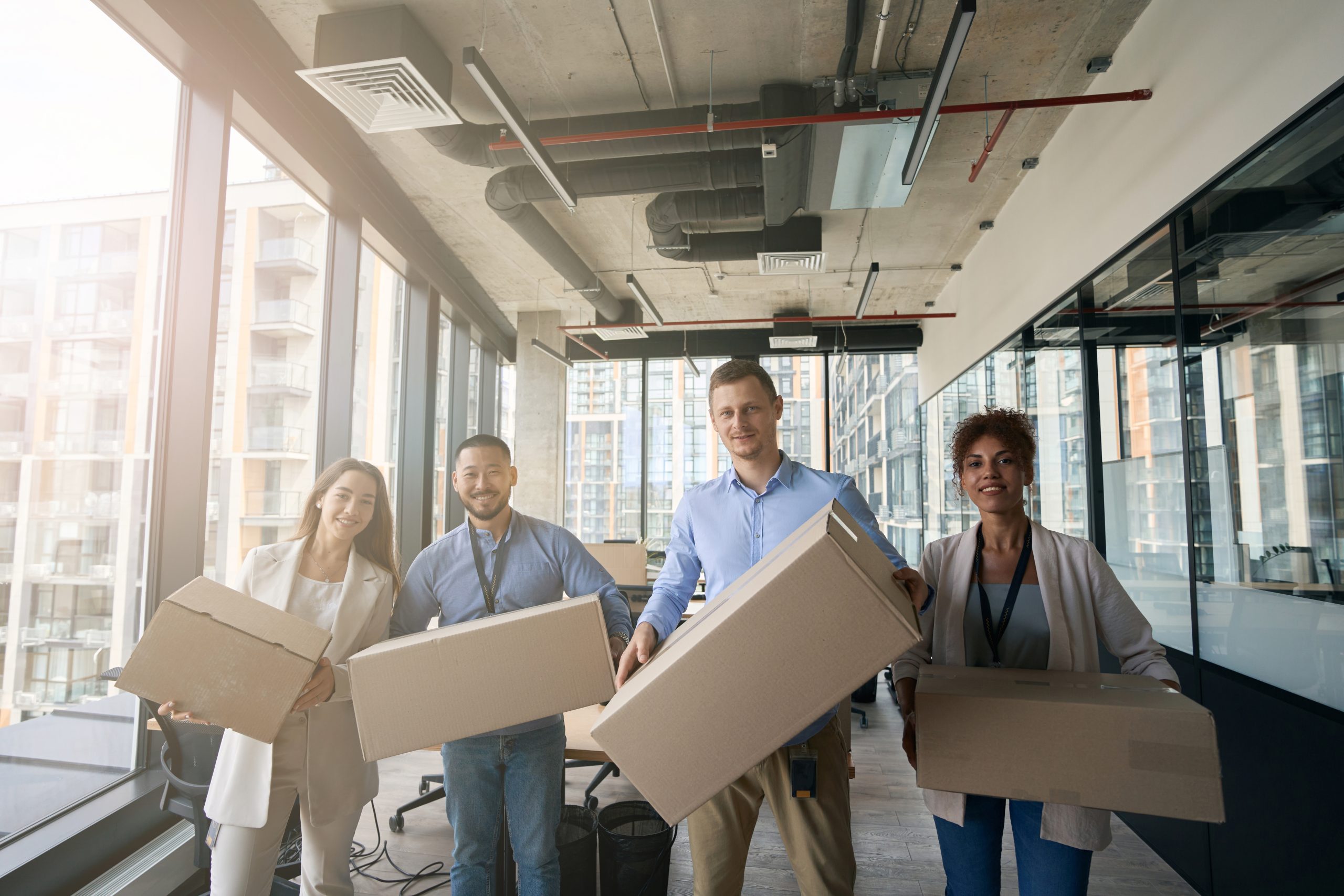 Four corporate employees posing for camera in workplace